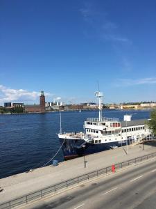 a large boat docked in the water next to a road at Gustaf af Klint in Stockholm