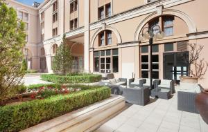 - un bâtiment avec une cour agrémentée de bancs et de fleurs dans l'établissement Odalys City Aix en Provence L'Atrium, à Aix-en-Provence