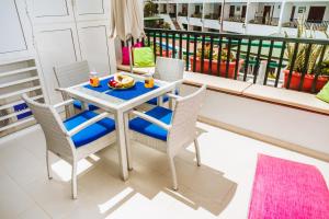 プエルト・デル・カルメンにあるBonito Apartamento & Piscinaのテーブル(椅子付)、バルコニー(フルーツボウル付)