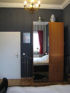 een slaapkamer met een bed, een spiegel en een dressoir bij Leibniz6 Stilvolles Privatzimmer in Leipzig
