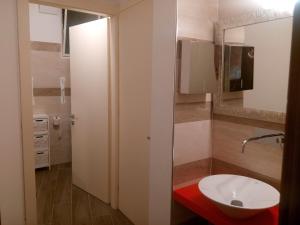 bagno con lavandino bianco e specchio di Hotel Telenia a Lido di Jesolo