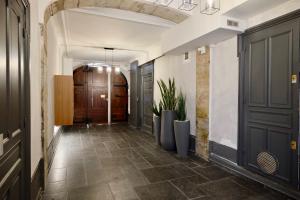 a hallway with black doors and a tile floor at Honorê - Suite François Dauphin in Lyon