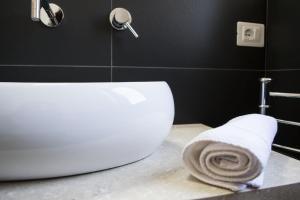 a bathroom with a white toilet and a towel on a counter at Four Winds B&B in Le Castella +45 photos