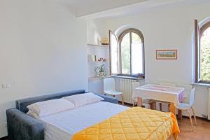 - une chambre avec un lit, une table et deux fenêtres dans l'établissement La Pineta, à Stresa