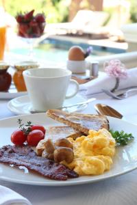 een bord ontbijtproducten met eieren en toast bij Plumwood Inn - Solar Power in Franschhoek
