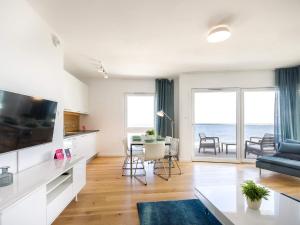 a living room with a television and a table at VacationClub - Przy Plaży Apartament 22 in Mielno