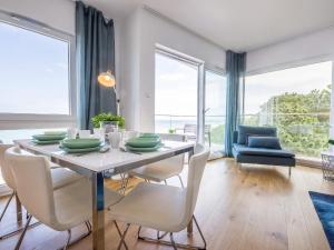 a dining room with a table and chairs with a view at VacationClub - Przy Plaży Apartament 22 in Mielno