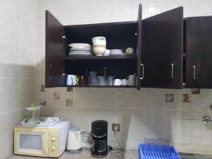 cocina con encimera y microondas en Residence Maya, en Abiyán
