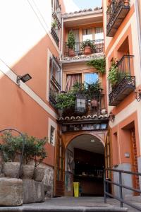un edificio con macetas al costado. en Hostal El Rincón, en Ávila