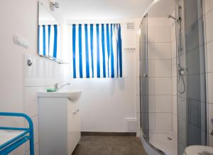 a white bathroom with a shower and a sink at Archipelag in Ustka +62 photos