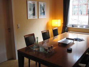 a dining room table with chairs and a wooden table at Leibniz6 Stilvolles Privatzimmer in Leipzig