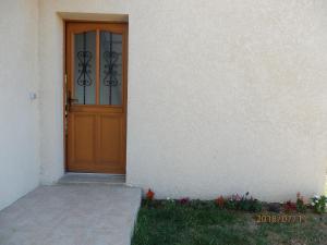 a wooden door of a white house with a porch at corse location in Linguizzetta