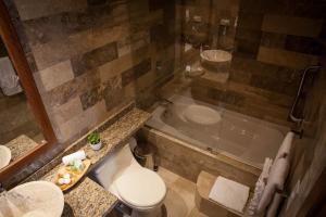 Ilalo Garden Hotel & Restaurant في كيتو: حمام مع مرحاض ومغسلة وحوض استحمام