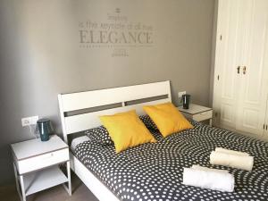コスタ・テギセにあるLos Charcosのベッドルーム1室(黄色い枕2つ付きのベッド1台付)