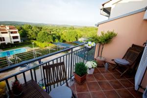 Un balcón con sillas y vista a una piscina. en Apartment Leonardo, en Rovinj
