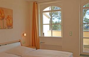 a bedroom with a bed and two windows at Baabe Gruene Duene Fewo Strandroma in Baabe