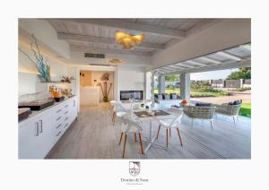 a kitchen and living room with a table and chairs at Destino di Nora in Pula