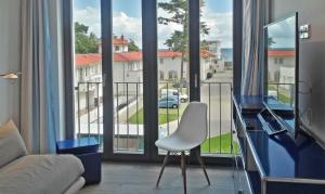 バーベにあるBaabe Villa Andrea Ferienwohnung Sのリビングルーム(窓の前に白い椅子付)