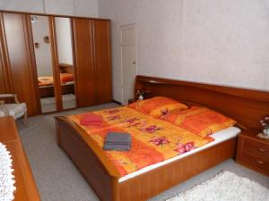 een slaapkamer met een bed met een houten frame en een spiegel bij Ferienwohnung Hahn in Sebnitz