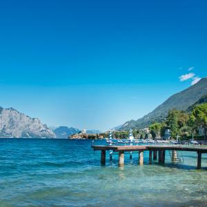 a pier in the water with people on it at Beach Hotel Du Lac Malcesine in Malcesine