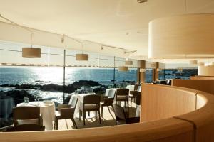 a restaurant with tables and chairs and a view of the ocean at Résidence Le Vénète in Le Croisic