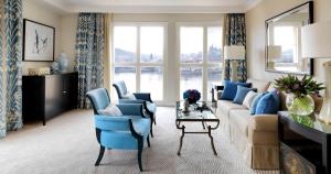 a living room with a couch and blue chairs at Four Seasons Hotel Prague in Prague