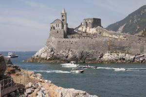 un castello su un'isola con barche in acqua di Settimo Piano a La Spezia