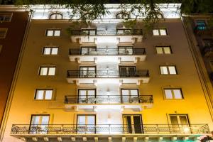 ein hohes gelbes Gebäude mit Balkonen in der Unterkunft LX51 Studios & Suites by APT IIN in Lissabon