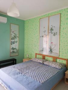 MongioveにあるCasa Filippa & Case Charlotte, Mongiove al mareの緑の壁のベッドルーム1室(ベッド1台付)