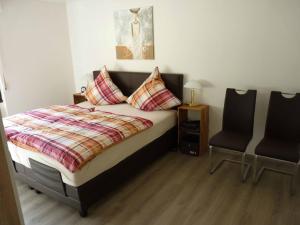 a bedroom with a bed and two chairs at Ferienwohnung Moselblick in Ediger-Eller