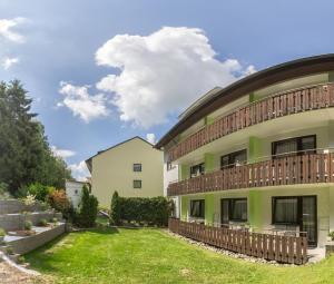 a green building with a balcony on the side of it at Pension Beck Hotel in Bad Waldsee