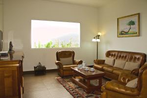 een woonkamer met een bank en 2 stoelen bij Quinta Tallinus in Funchal