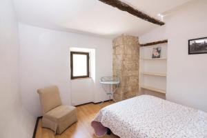 a bedroom with a bed and a chair and a window at Chambre d'hotes - Ferme de Chanteraine in Aiguines