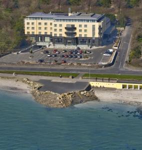 a large building with a parking lot next to the water at Salthill Hotel in Galway