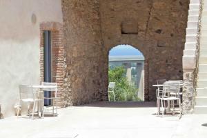 un grupo de sillas y mesas en un edificio en Borgo d'Orlando - Country Boutique Hotel en Mirto