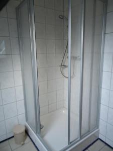eine Dusche mit Glastür im Bad in der Unterkunft Gästehaus Steffen in Upgant-Schott