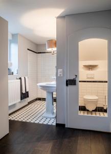 a bathroom with a white sink and a toilet at Landcafe mit Mini Hotel in Burgdorf