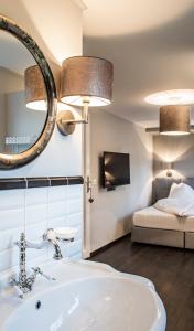 uma casa de banho com um lavatório, um espelho e uma cama em Landcafe mit Mini Hotel em Burgdorf