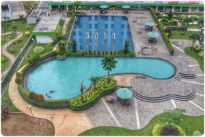 einen Blick über den Pool eines Resorts in der Unterkunft Green Lake View - Tower E 59 Acuan Laundry Time in Pondokcabe Hilir
