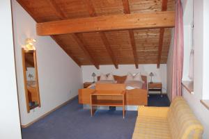 - un salon avec un lit et un canapé dans l'établissement Pension Demmel, à Bruckmühl