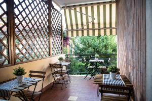 a patio with tables and chairs and a large window at Dora’s Room in Pescara