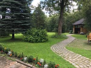 a garden with a stone path and flowers at Hanusina Chałupa Wynajem pokoi in Zakopane