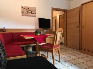 a living room with a red table and a red couch at Appartements Kröll in Saalbach-Hinterglemm