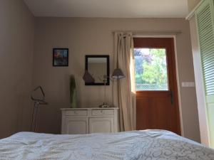 a bedroom with a bed and a window and a dresser at La Maison des Artistes in Auxerre