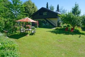 un patio con mesa y sombrilla en Landhaus Bernecker, Bay.W., en Rinchnach