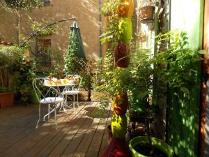 un patio con mesa y sillas en una terraza en La Maison Du Bonheur en Aups