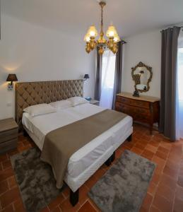 a bedroom with a large bed and a chandelier at L'Escale in Bonifacio