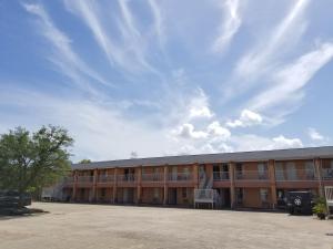 un edificio escolar vacío con una silla en el patio en Maxim III Motel, en Houston