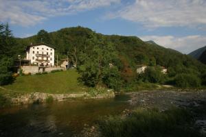 a house on a hill next to a river at Albergo Alla Trota in Pulfero