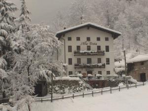 a snow covered building with a sign on it at Albergo Alla Trota in Pulfero +5 photos